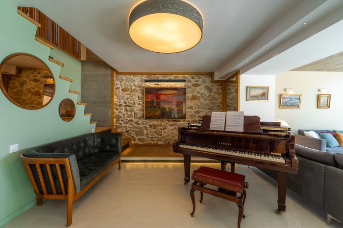 Salon, mur de pierre et piano à queue - Villa Bonne Brise